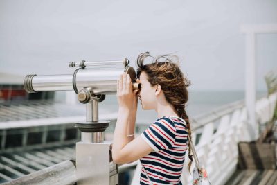 Young girl looking through a telescope.