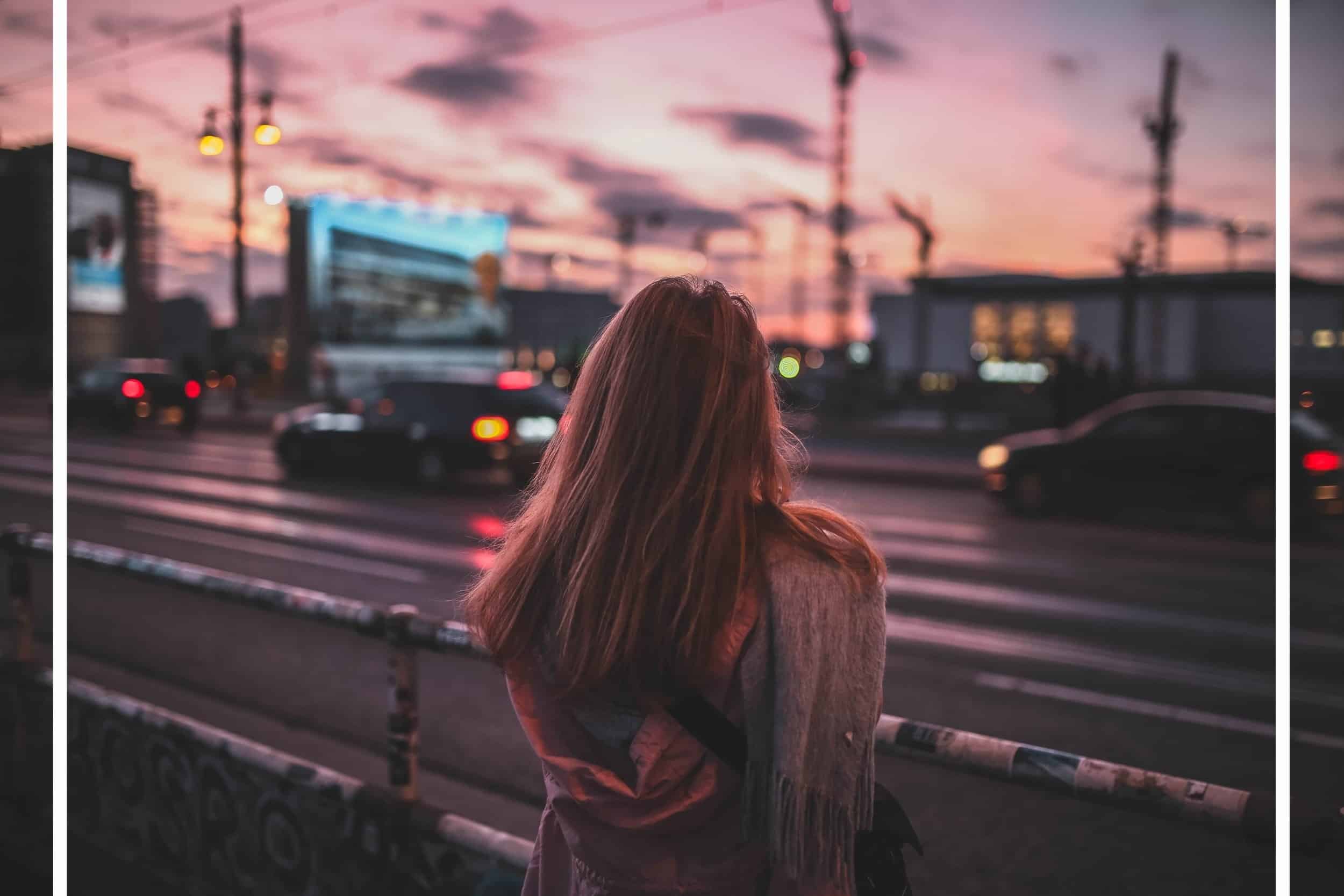 Woman looking out onto a busy street.