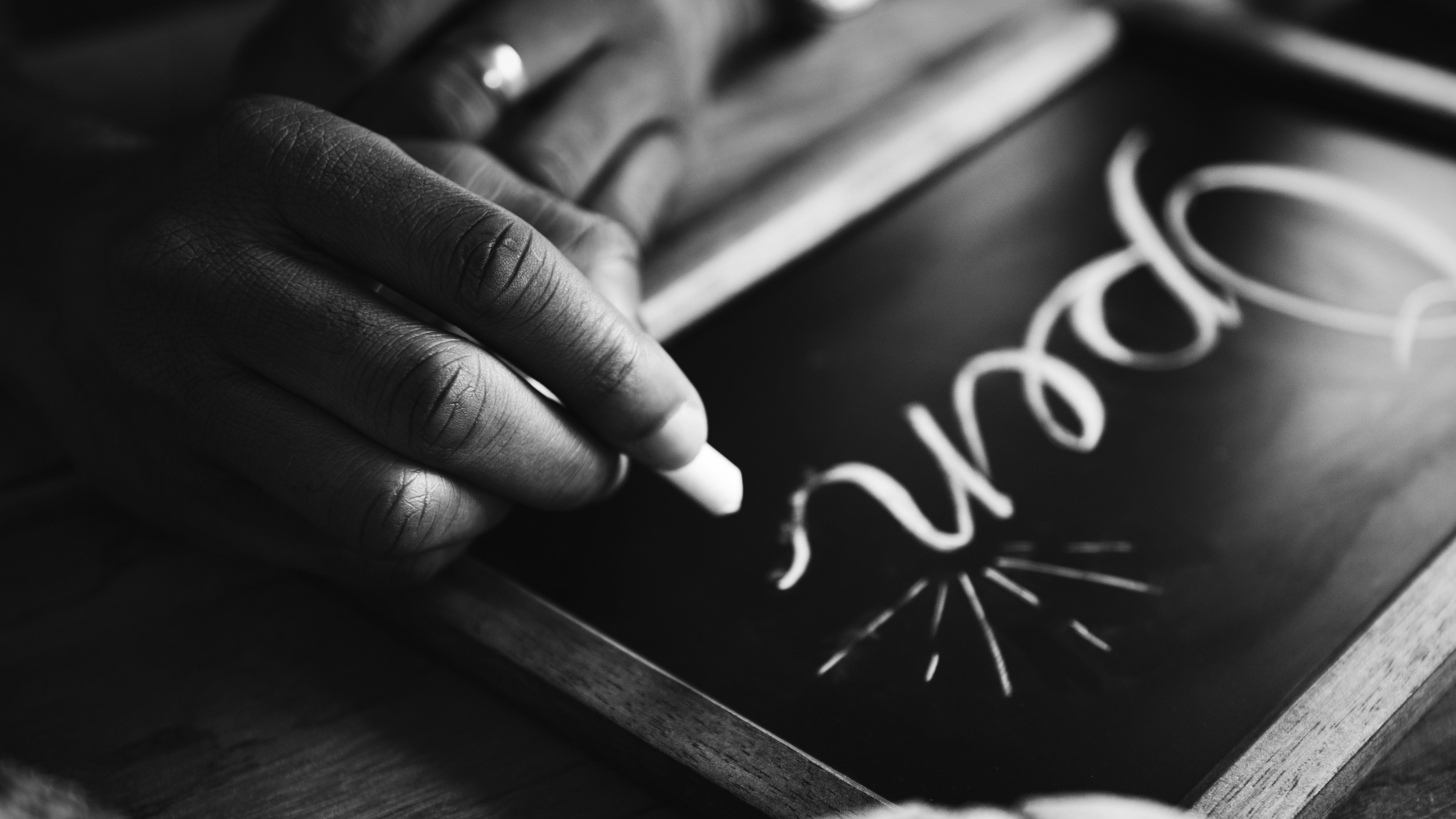 Person writing open on a chalkboard.