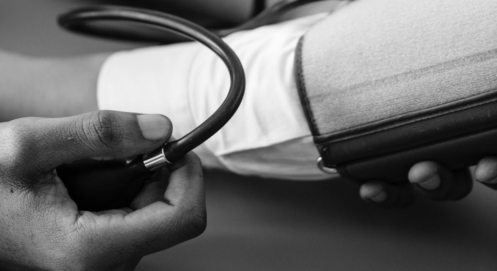 Clinician taking blood pressure of patient.