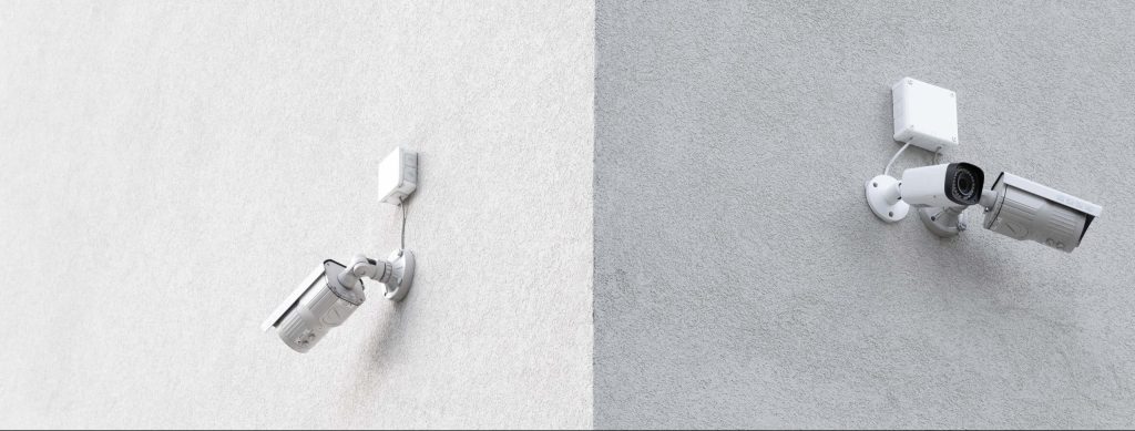 Security cameras mounted on adjacent gray walls.