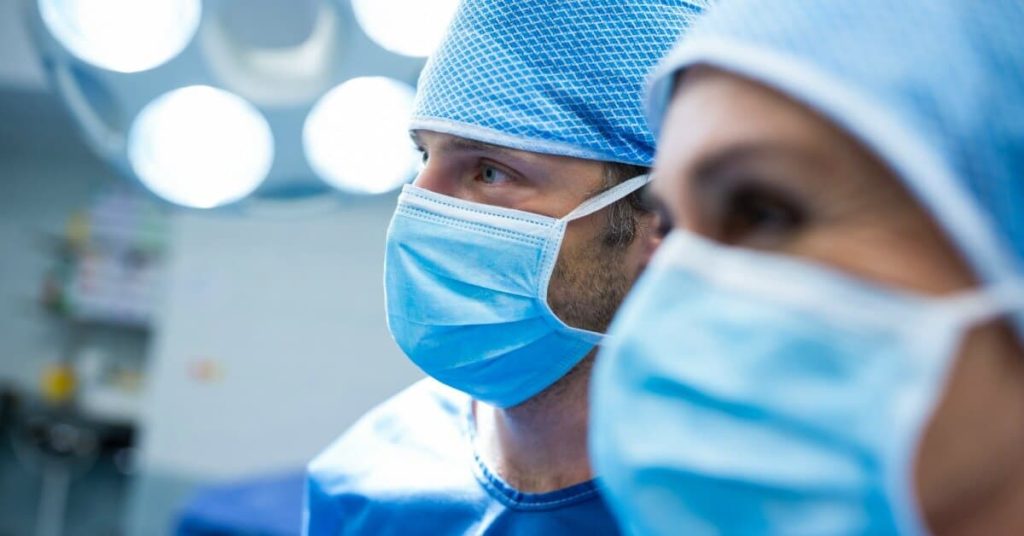 Surgical professionals collaborating together in operating room.