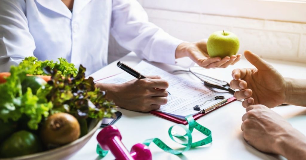 Nutritionist giving consultation to patient with healthy fruit and vegetable, Right nutrition and diet concept