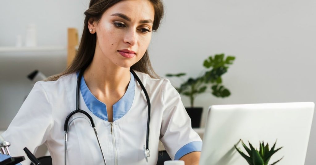 Clinician meeting with a patient on a laptop.
