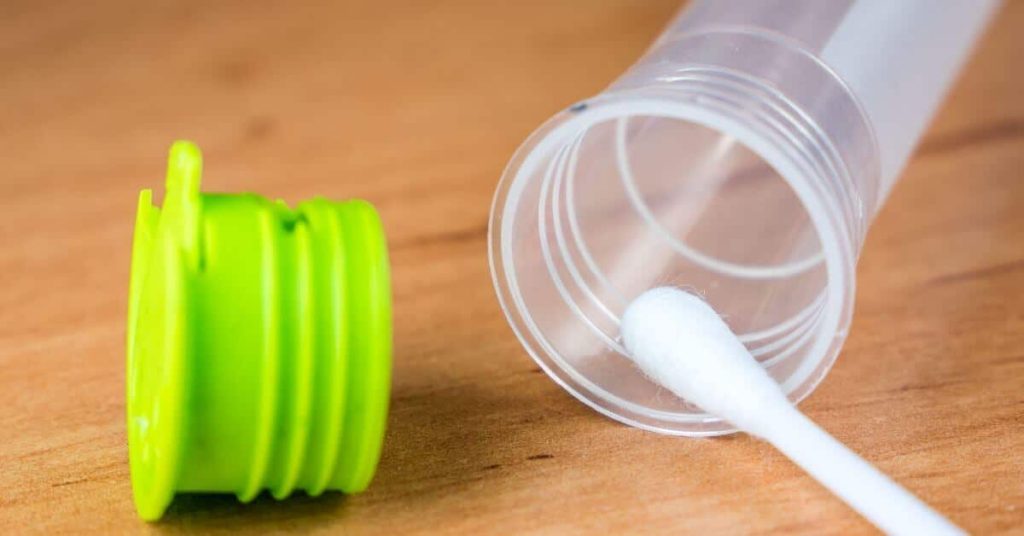 At-home COVID-19 test swab inserted in a tube.