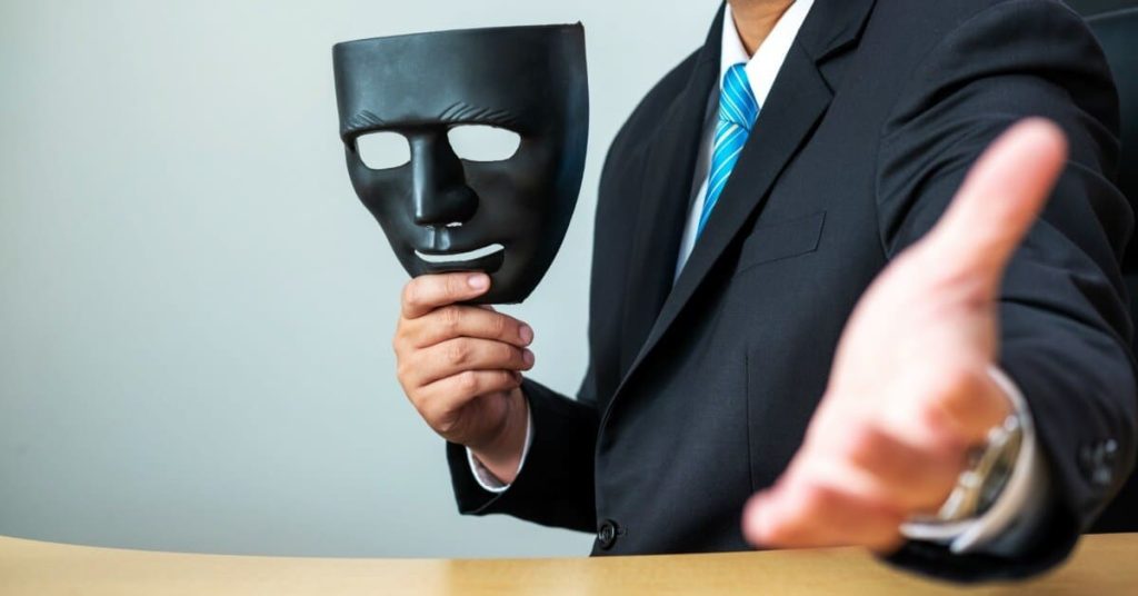 Man beckoning someone with a mask in hand.