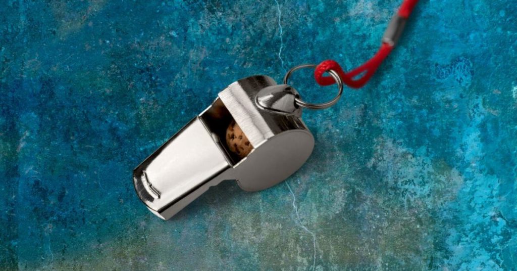 Silver whistle on blue background.