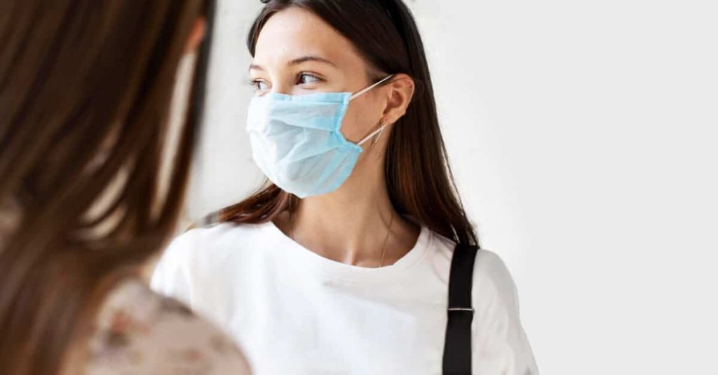 A masked employee talks to employer about requesting time-off.