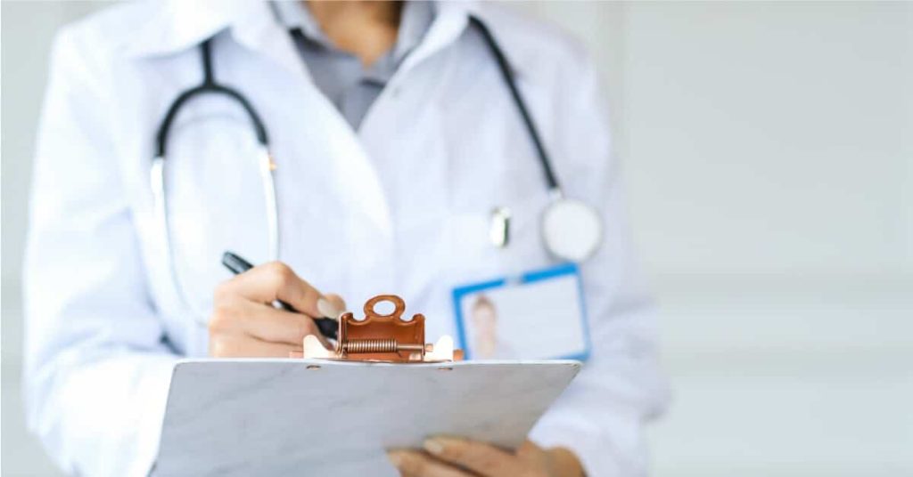 Physician checking off things on a clipboard.