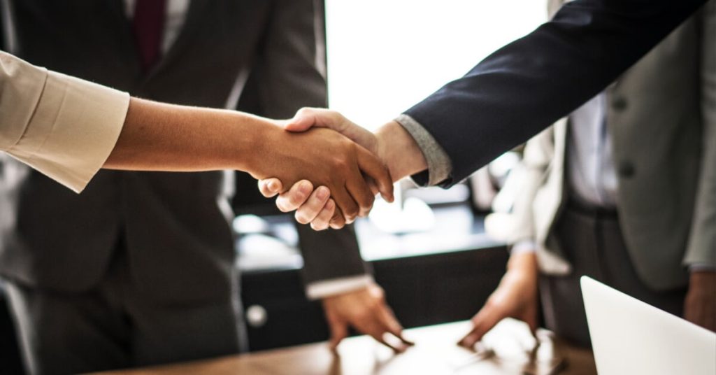 Business professionals shaking hands in a meeting.