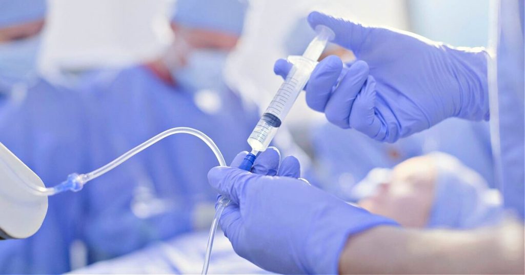 Medical professional administering anesthesia to a patient.