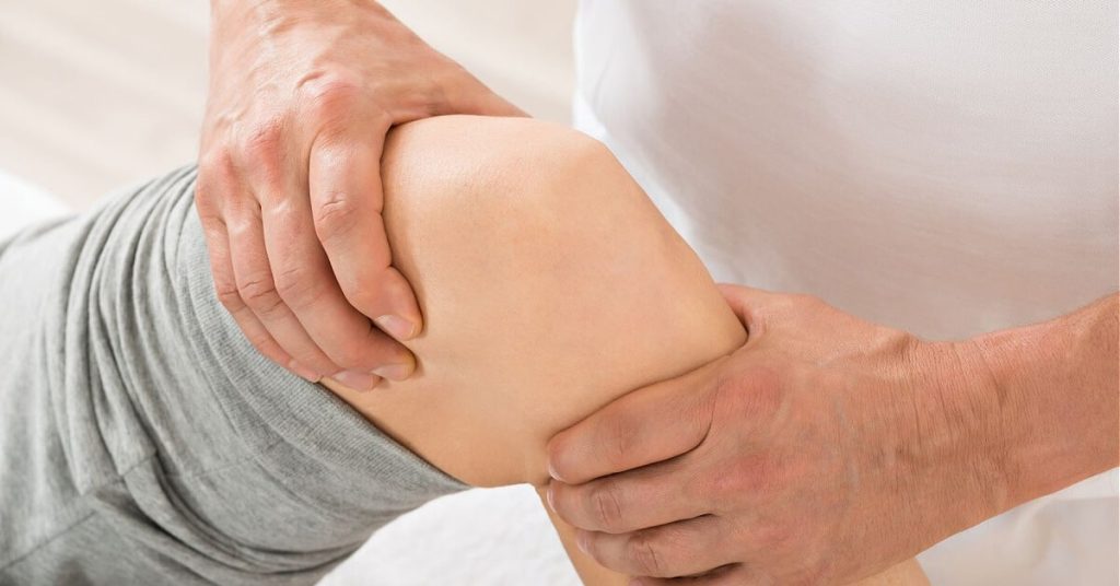 Physical therapist practicing an exercise with a patient.