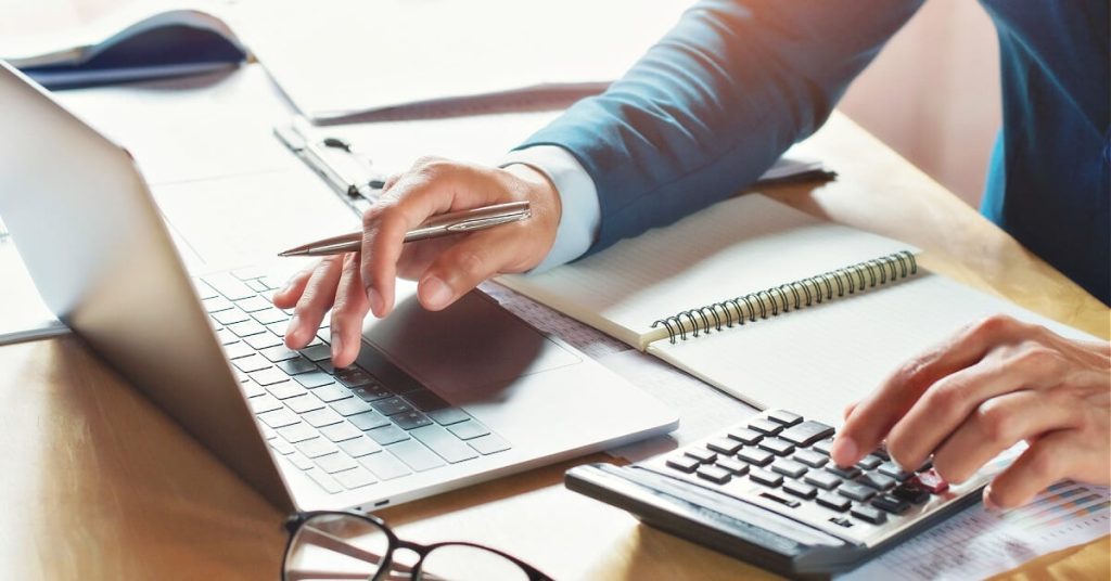 Accountant working on business entities on a laptop.