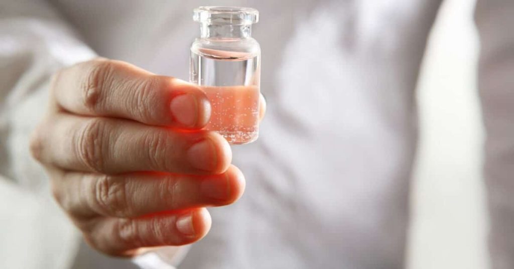 Clinician holding a vial of the COVID-19 vaccine.