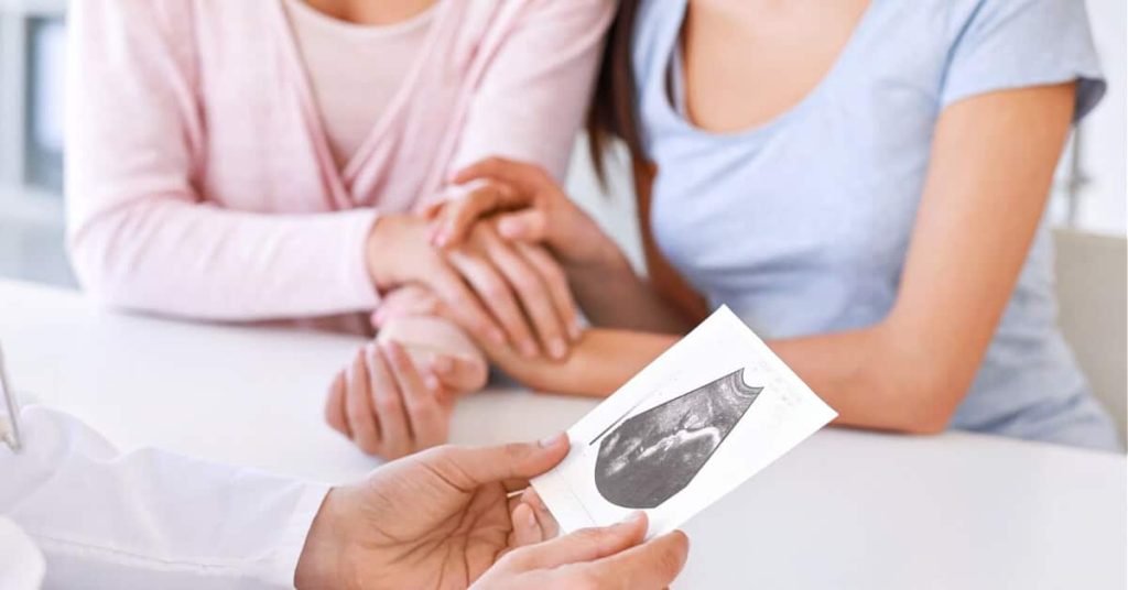 LGBTQ patients consulting their doctor on pregnancy.
