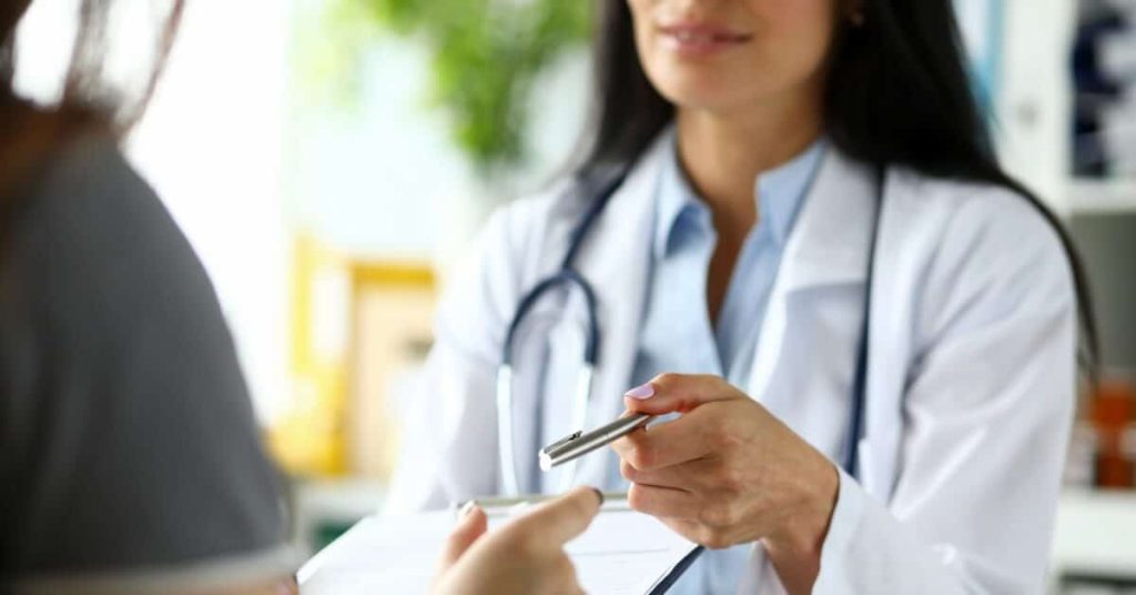 A physician handing over a consent agreement to a patient.