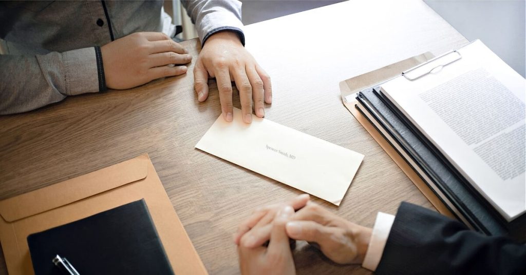 Employee handing over a resignation letter to his boss.