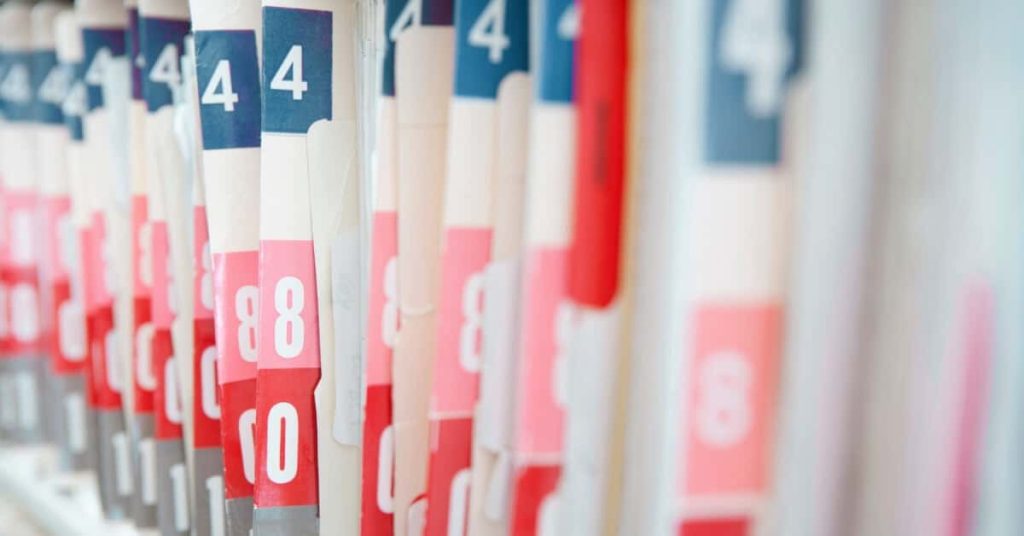 Paper medical records on a shelf.