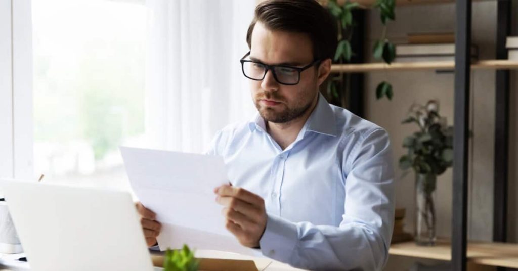 Man reading an insurance clawback notification.