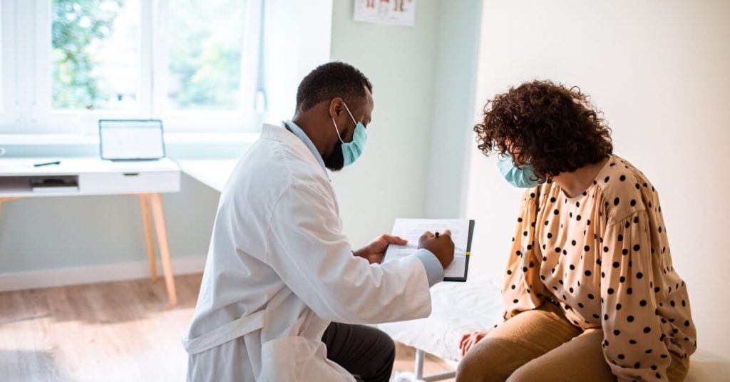 A PA and a patient in an examination room.