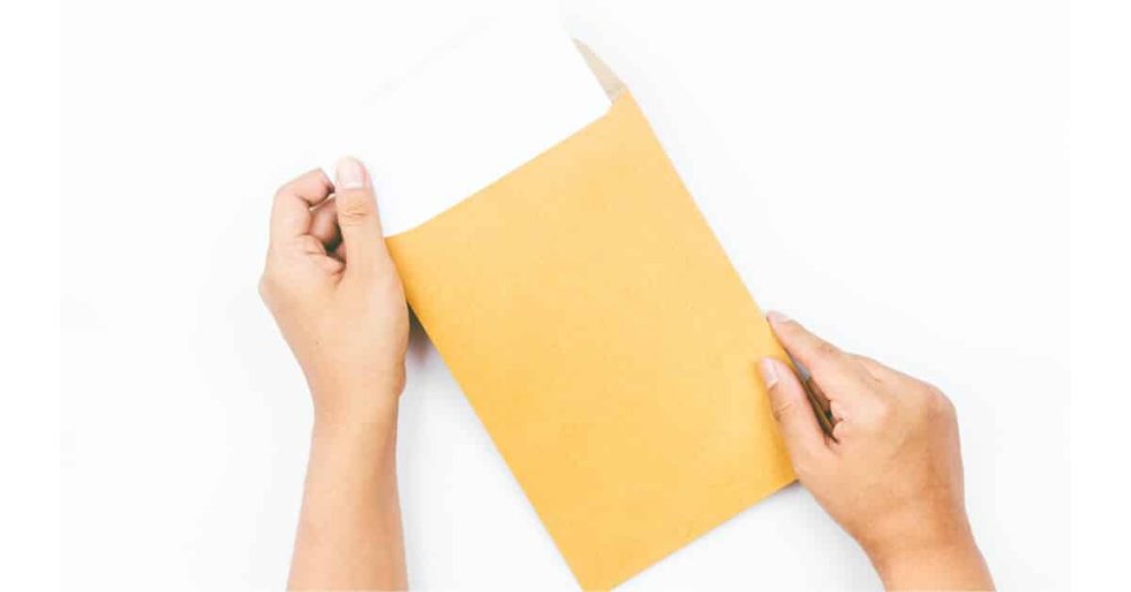 Person's hands opening a thick envelope