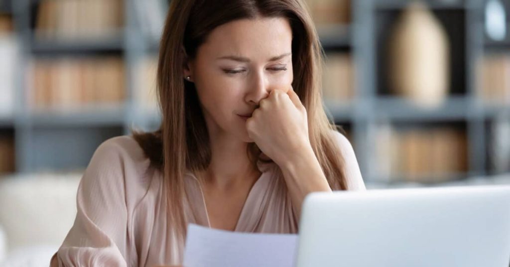 Concerned woman looking at a paper document.