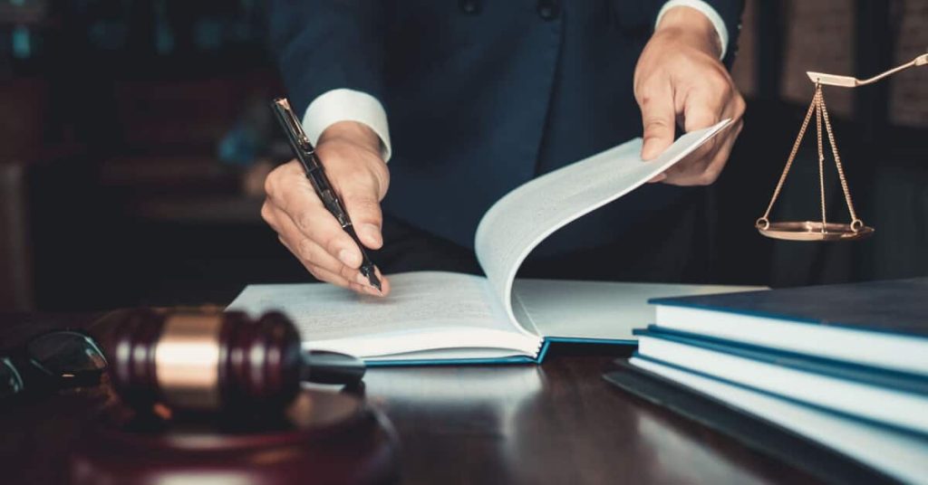 Man signing a bound document.