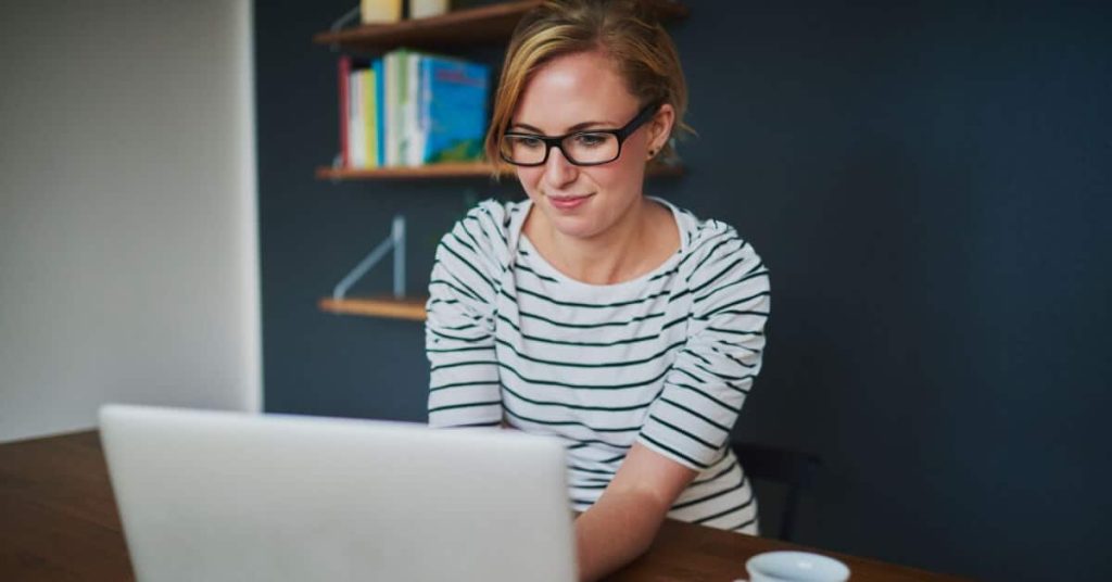 Seated woman looking at a laptop screen.