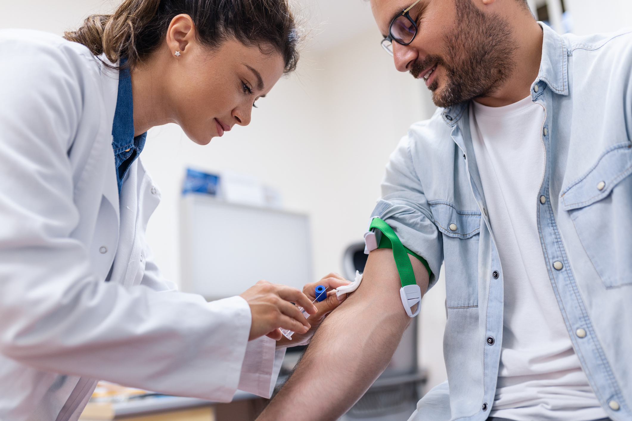 Female physician performing point-of-care blood testing on a patient in a private practice office