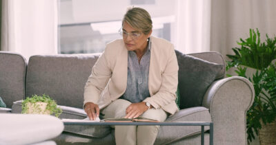 Illinois mental health provider reviewing self-assembled DIY patient intake forms while seated on a couch.