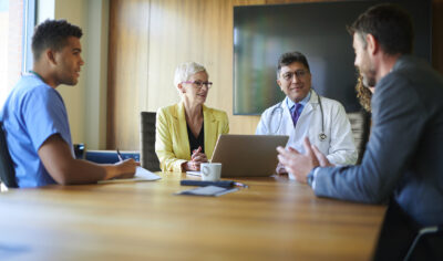 Physician and non-physician owners discuss what an MSO is in healthcare law during a meeting