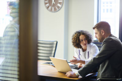 Physician and healthcare attorney reviewing Stark Law compliance documents during an MSO consultation