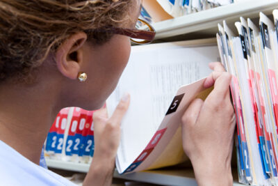 Healthcare worker retrieving a paper patient record, illustrating HIPAA compliance for private practices