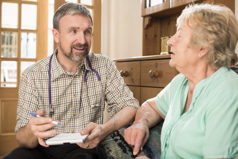 Physician talking with an older patient during a concierge medicine appointment.
