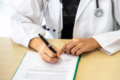 A physician signs a contract.